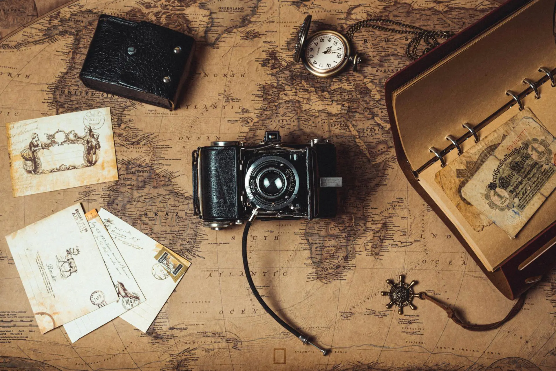Vintage personal belongings on a desk, including antique cameras, old photographs, and heirloom jewelry, representing estate treasures and collectibles.