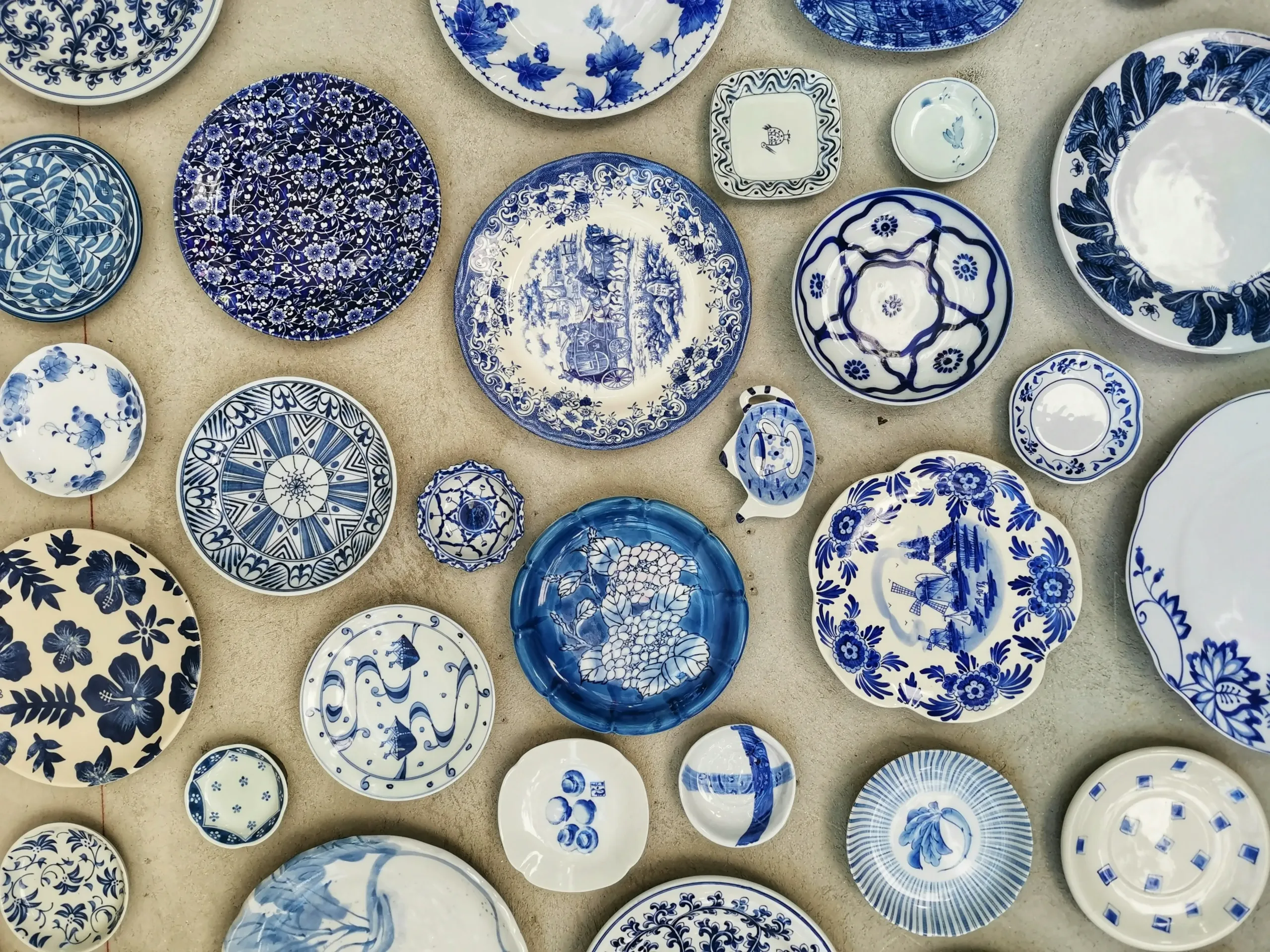 A collection of antique blue and white porcelain dishes featuring intricate floral and geometric patterns, available at a Messina & Park estate sale.