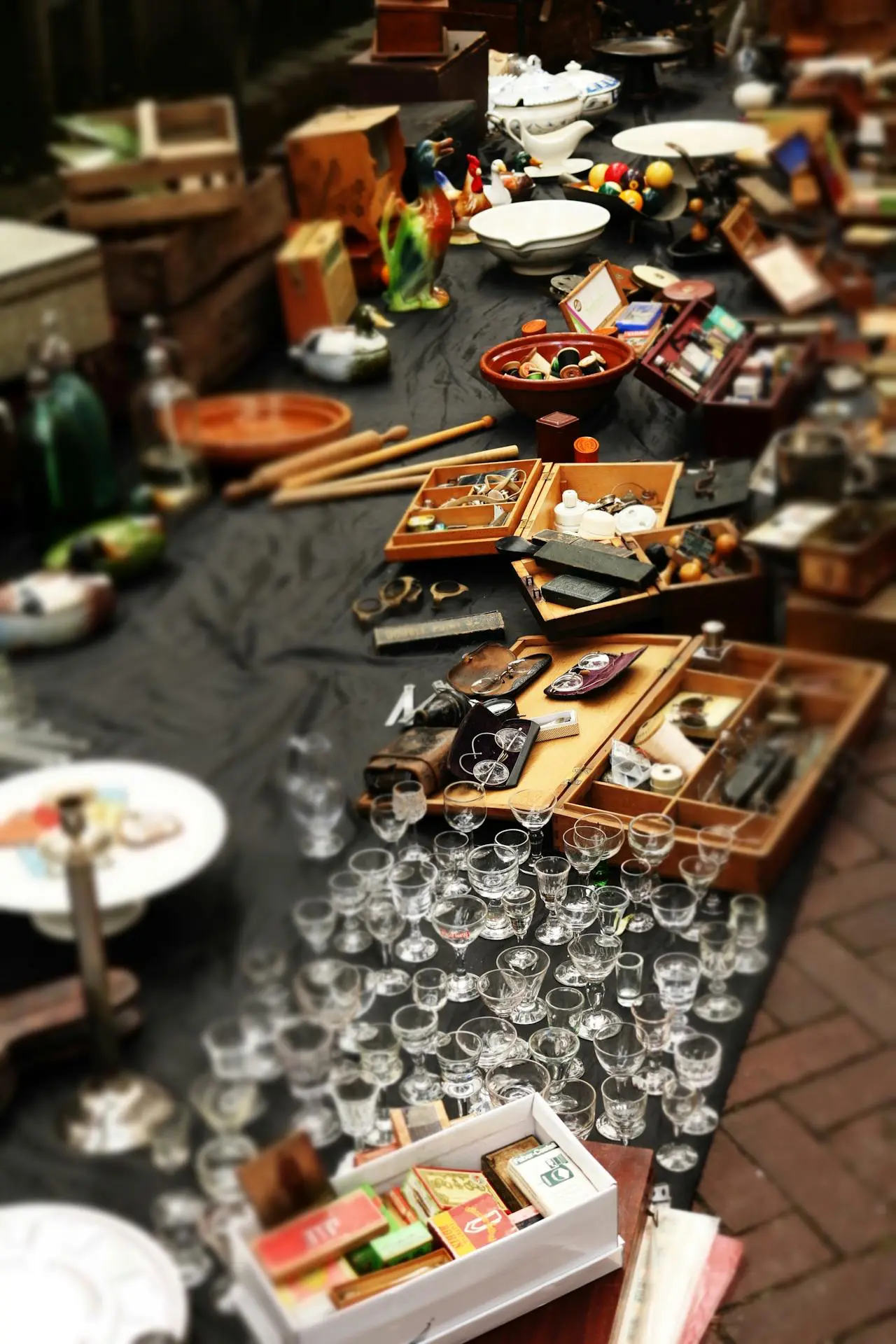 Antique & Vintage Collectibles – Estate Sale Finds & Appraisals Table display featuring vintage and antique items, including trinkets and glassware, available at an estate sale.