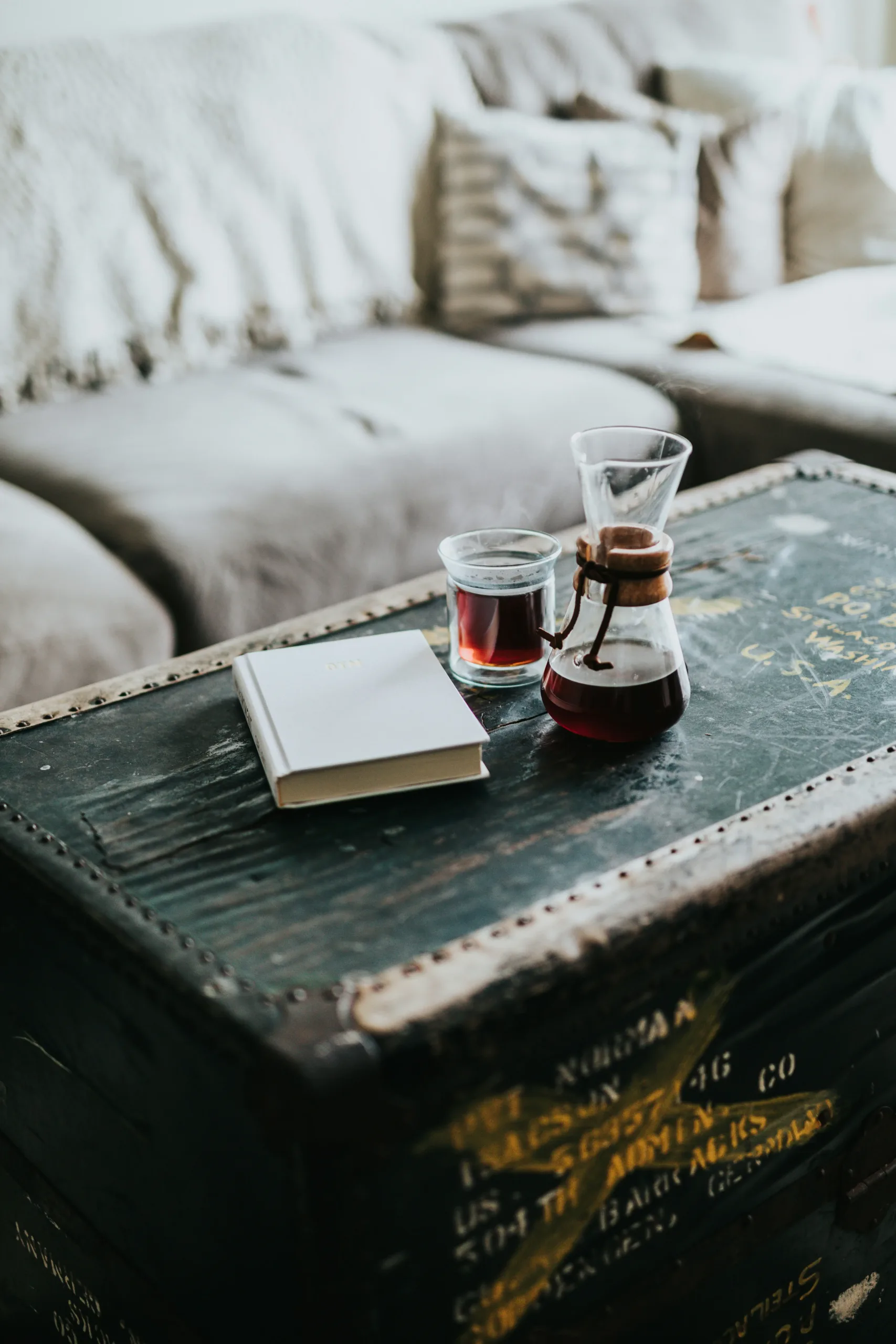 Antique Trunks & Timeless Collectibles – Estate Sale Treasures A steaming cup of coffee resting on a vintage trunk, symbolizing nostalgia, antiques, and timeless collectibles.