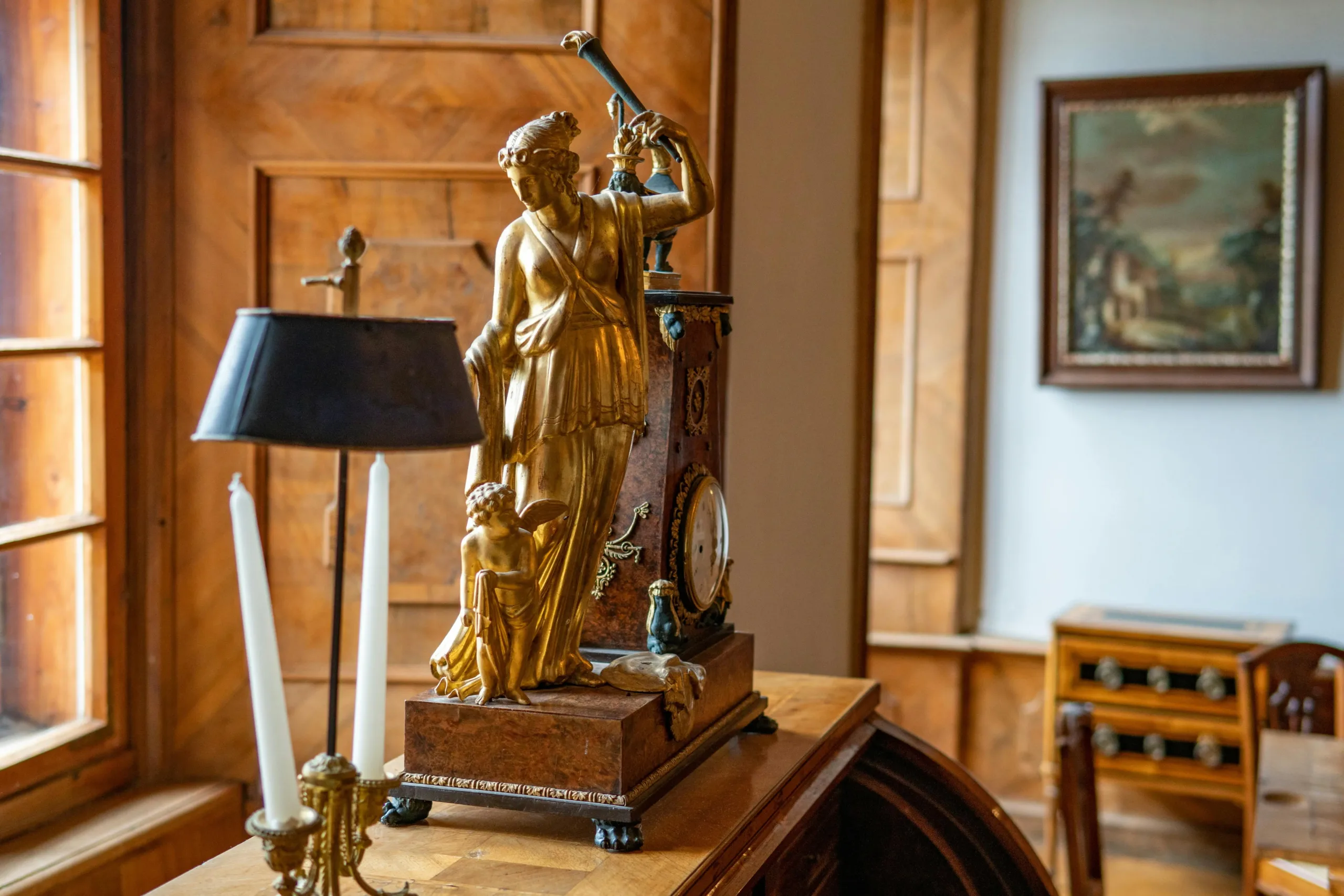 Elegant living room featuring a porcelain statue and gold candlestick holders, showcasing timeless antiques and luxury decor.