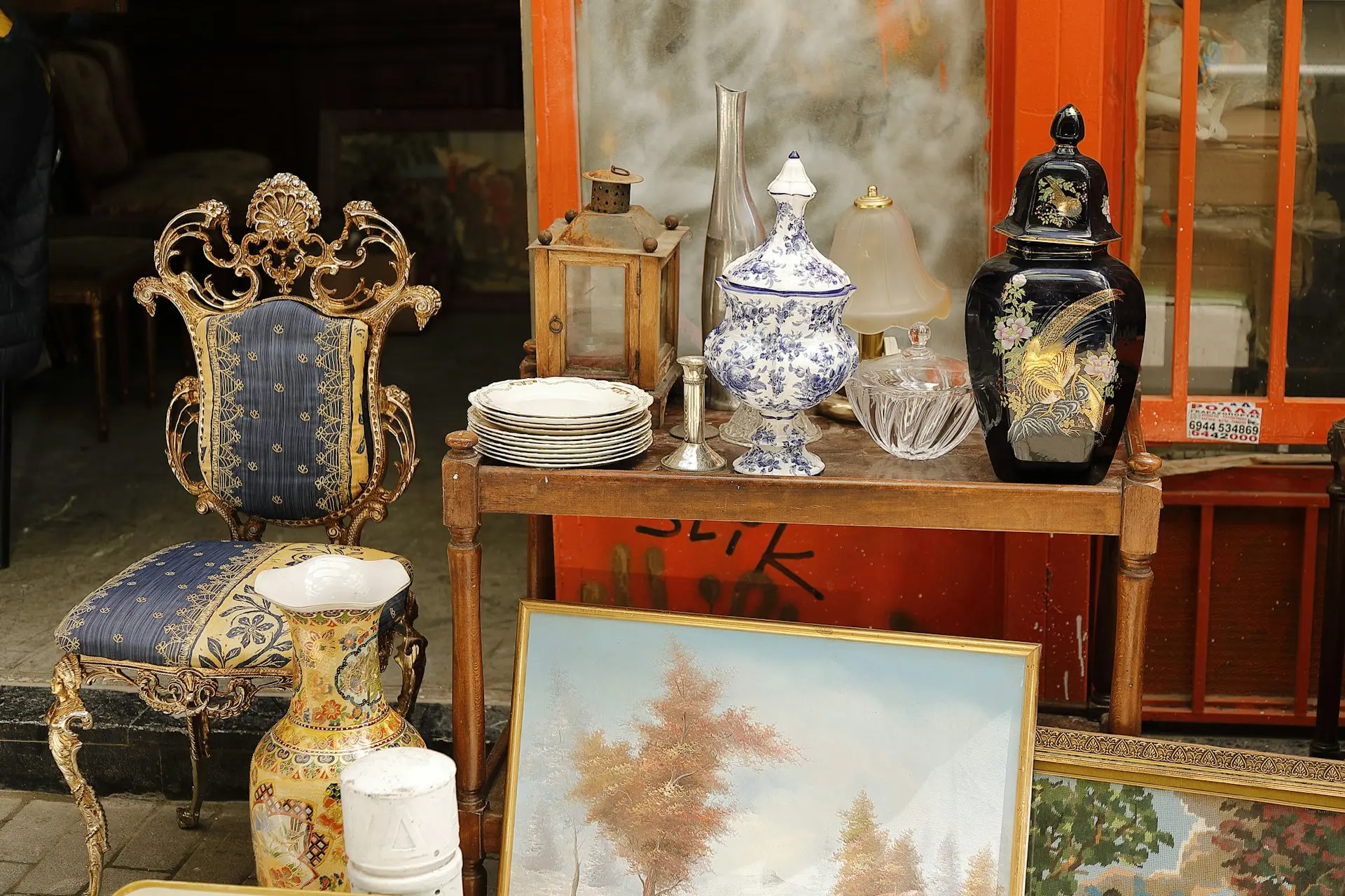 Antique Art & Decor – Exclusive Estate Sale Finds & Collectibles Table display featuring antique art, vintage lamps, and decorative collectibles, available for sale at an estate sale.